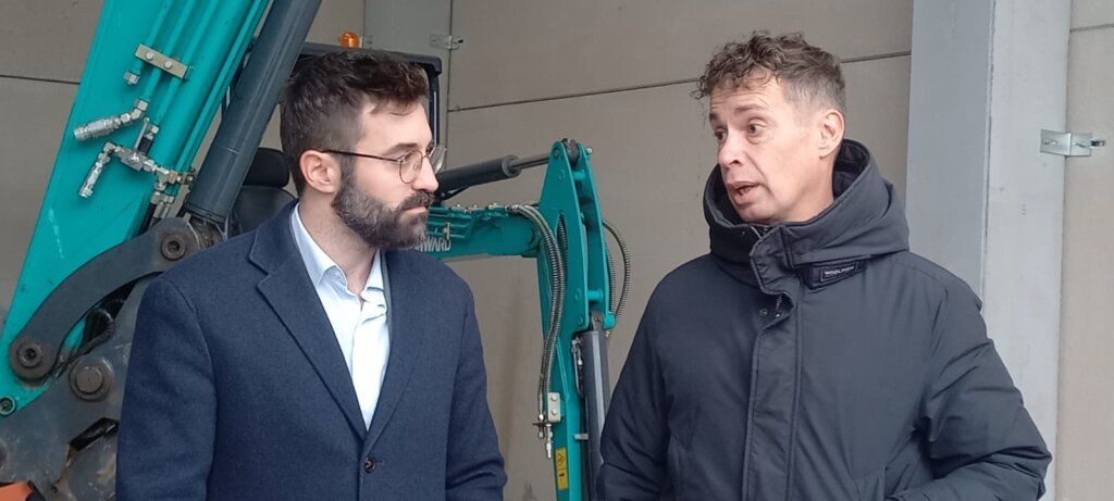 Visita al centro de biomasa de Orallo con dos hombres conversando.