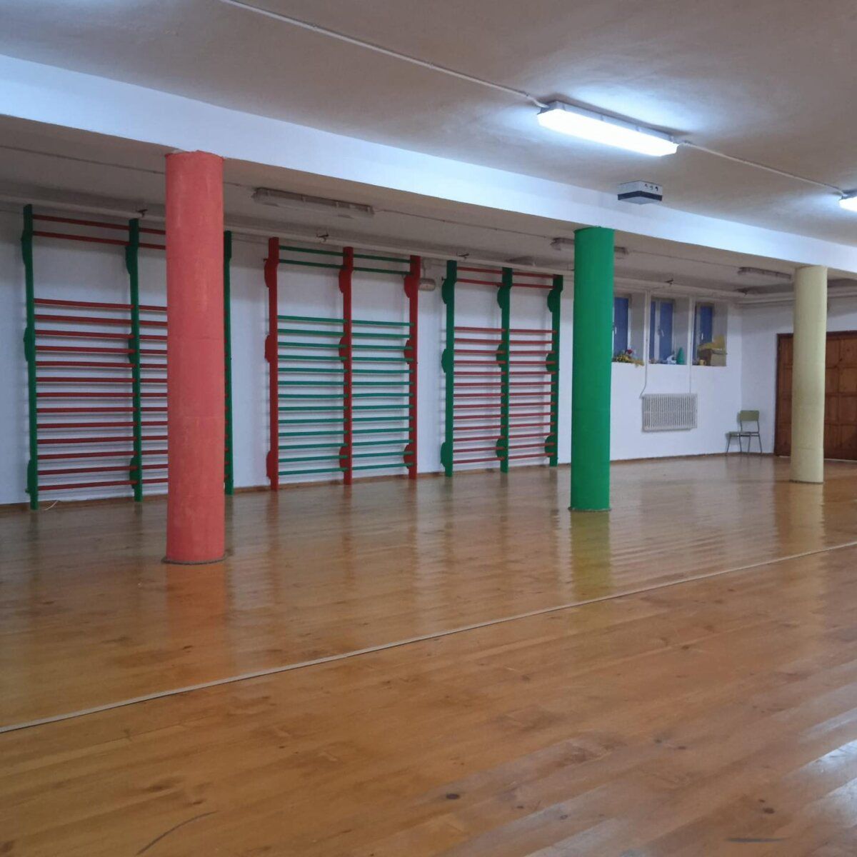 Interior del Colegio San Miguel con paredes de colores y suelo de madera