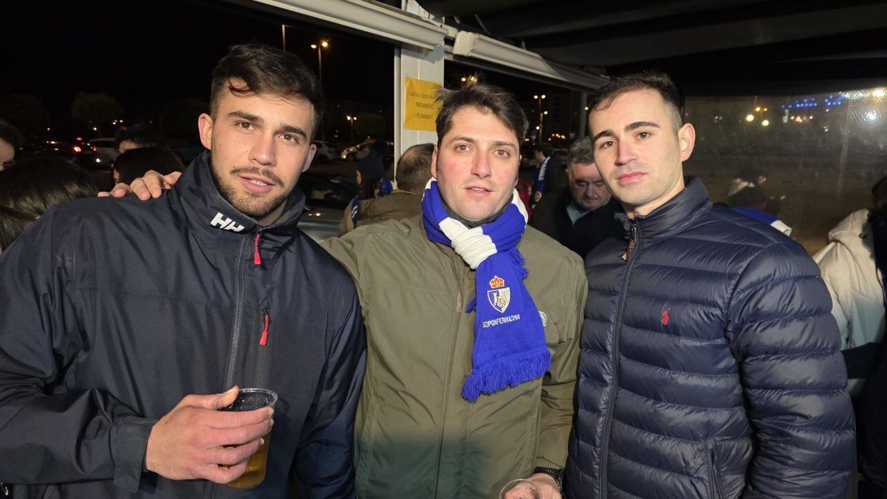 Tres aficionados de la Ponfe en un evento nocturno con bebidas.