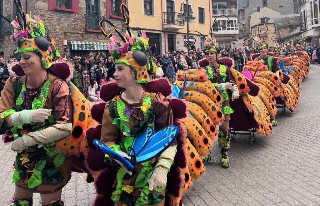 Participantes del carnaval en Arganza con trajes coloridos y mariposas