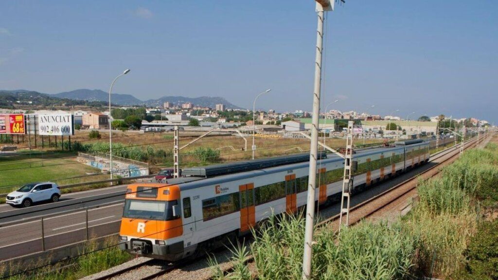 Tren de Cercanías circulando por Barcelona en un día soleado