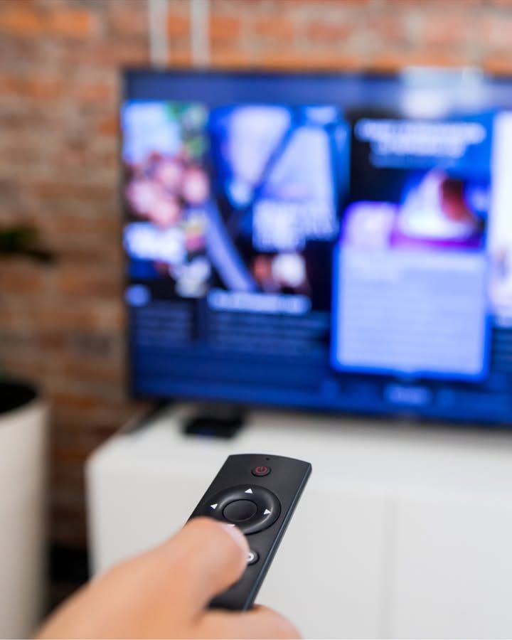 Control remoto apuntando a un televisor con contenido digital