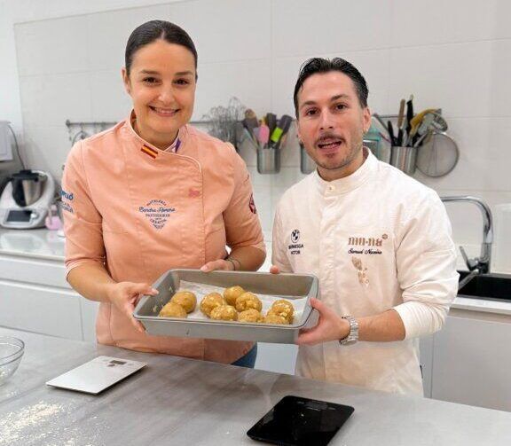 Sandra Romero y Samuel Naveira sosteniendo una bandeja con galletas