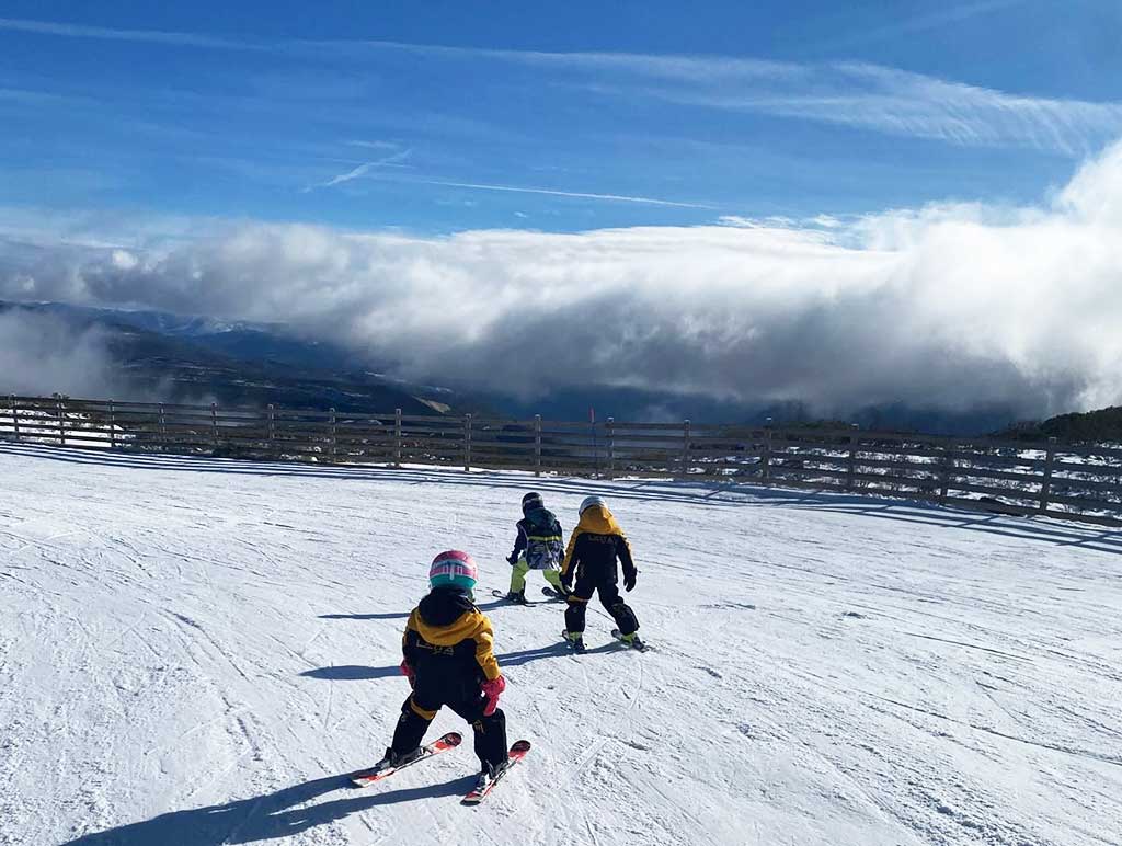 Niños esquiando en el Valle Laciana-Leitariegos con paisaje montañoso