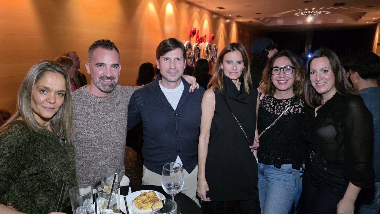 Grupo de amigos disfrutando en una fiesta temática de los 80 y 90 en un casino