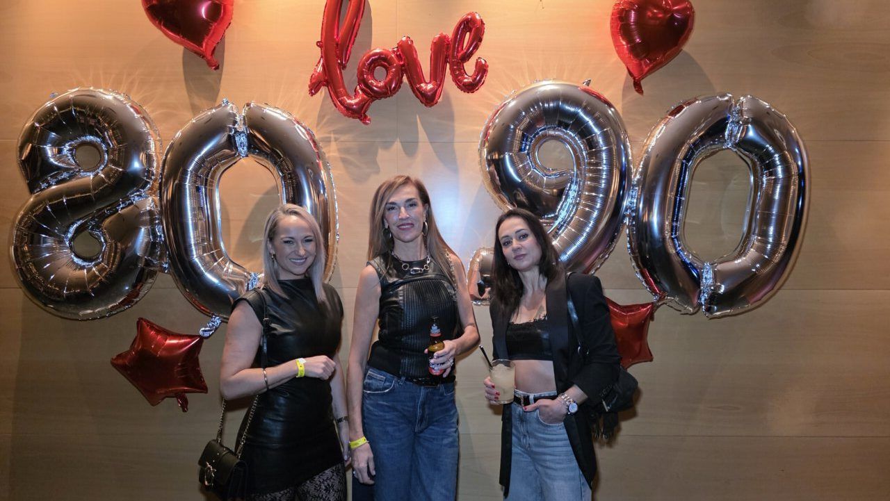 Tres mujeres posando en una fiesta temática de los años 80 y 90