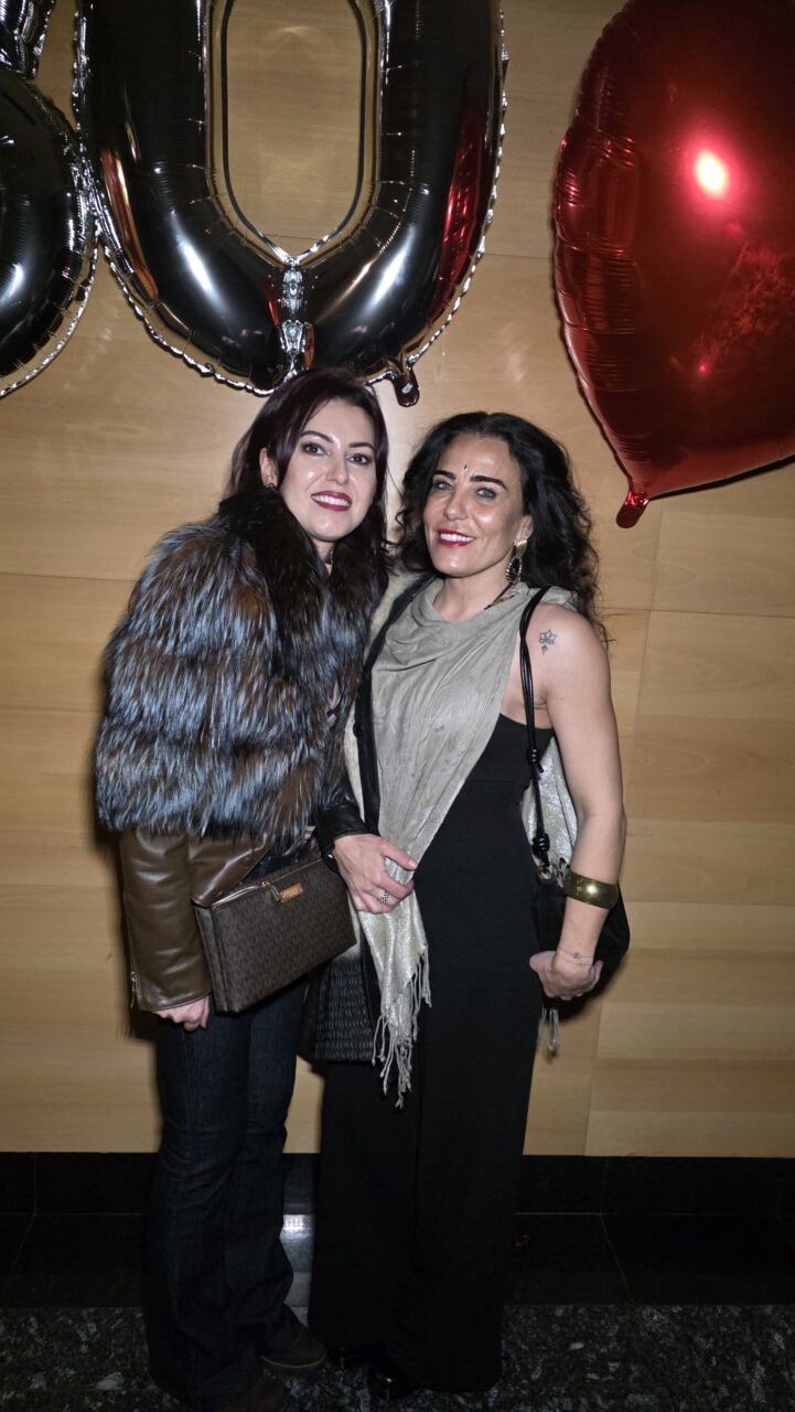 Dos mujeres posando en una fiesta de los años 80 y 90 con globos.