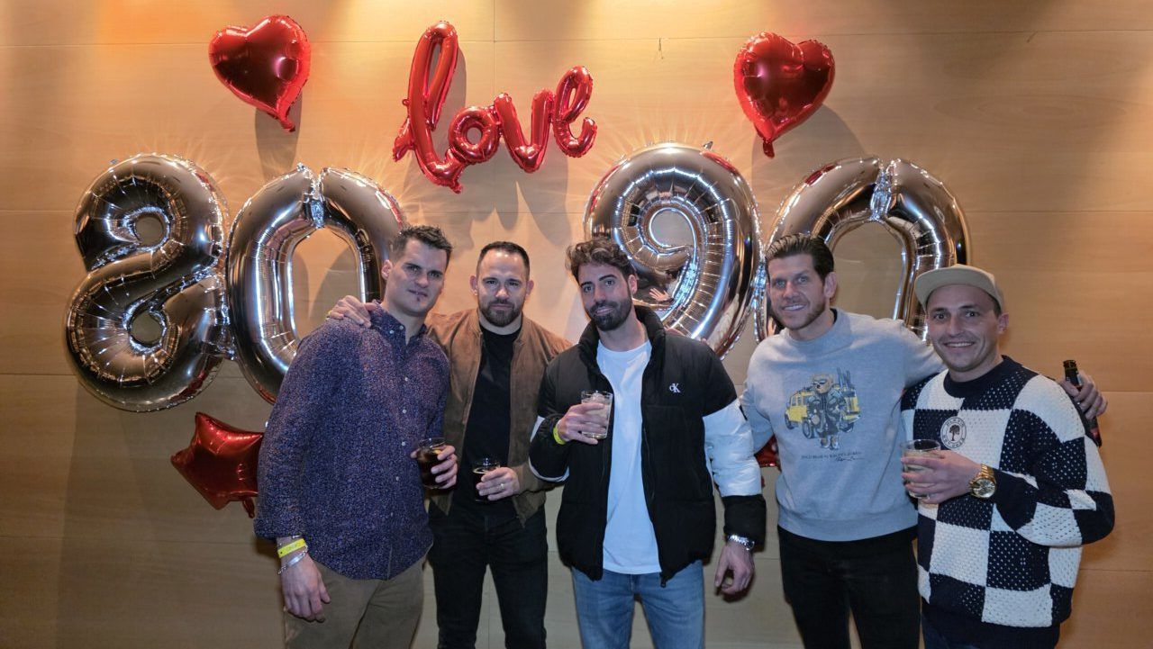 Grupo de amigos celebrando en fiesta temática de los 80 y 90