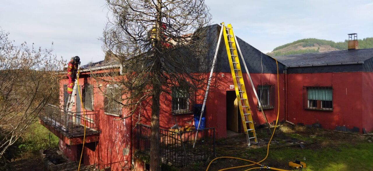 Bomberos trabajando en el techo de una vivienda en Molinaseca tras un incendio