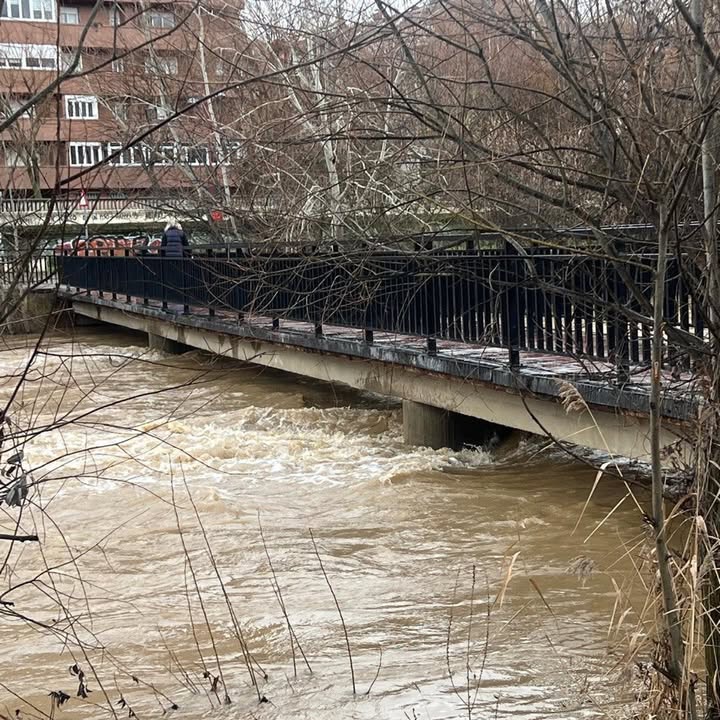 Pasarela peatonal cerrada debido al aumento del caudal del río Bernesga en León.