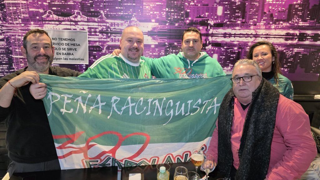 Grupo de aficionados del Racing de Ferrol con bandera en un bar