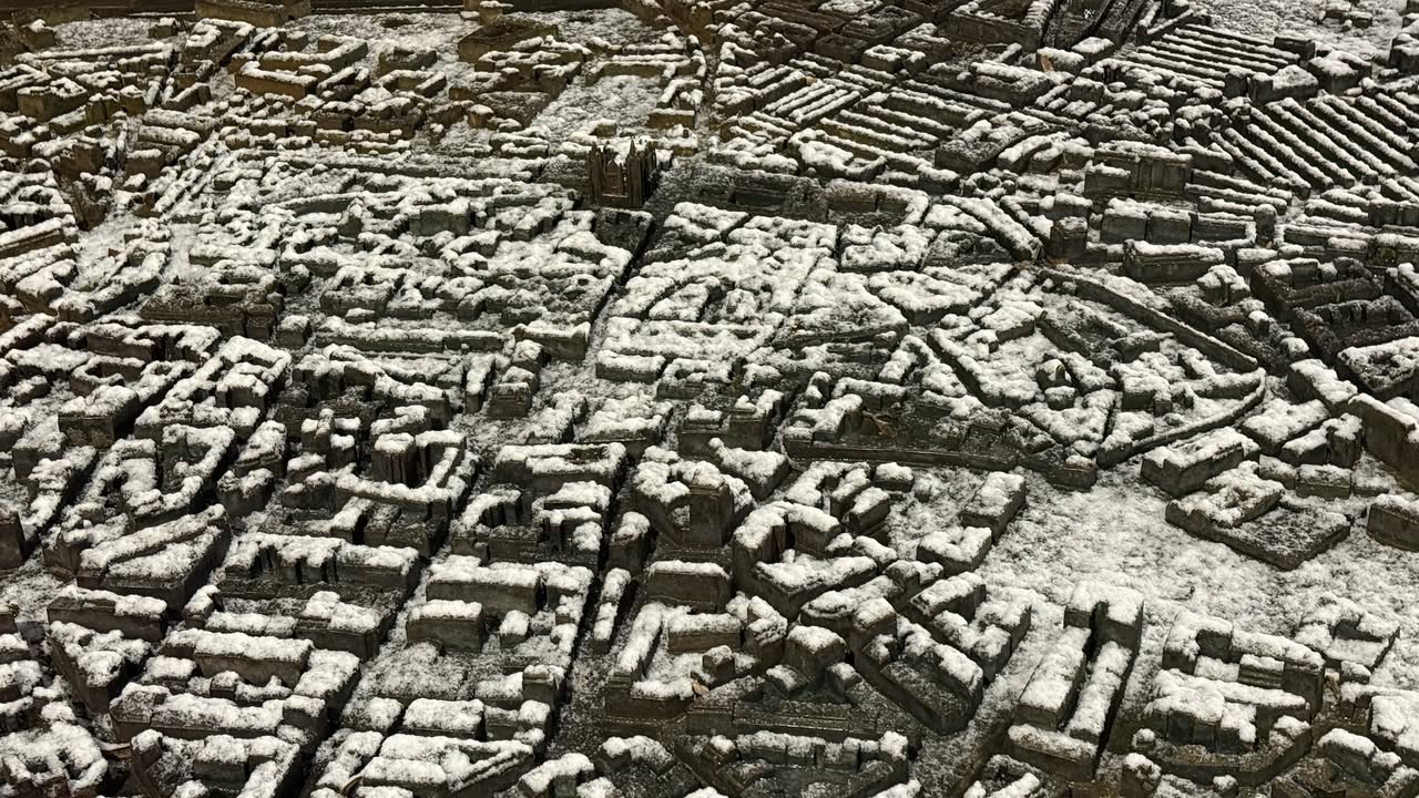 Vista aérea de la maqueta de León cubierta de nieve en un amanecer