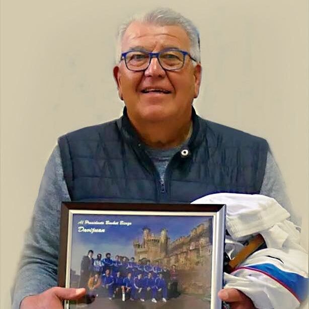 Manolo Copano sosteniendo una fotografía de su equipo de baloncesto