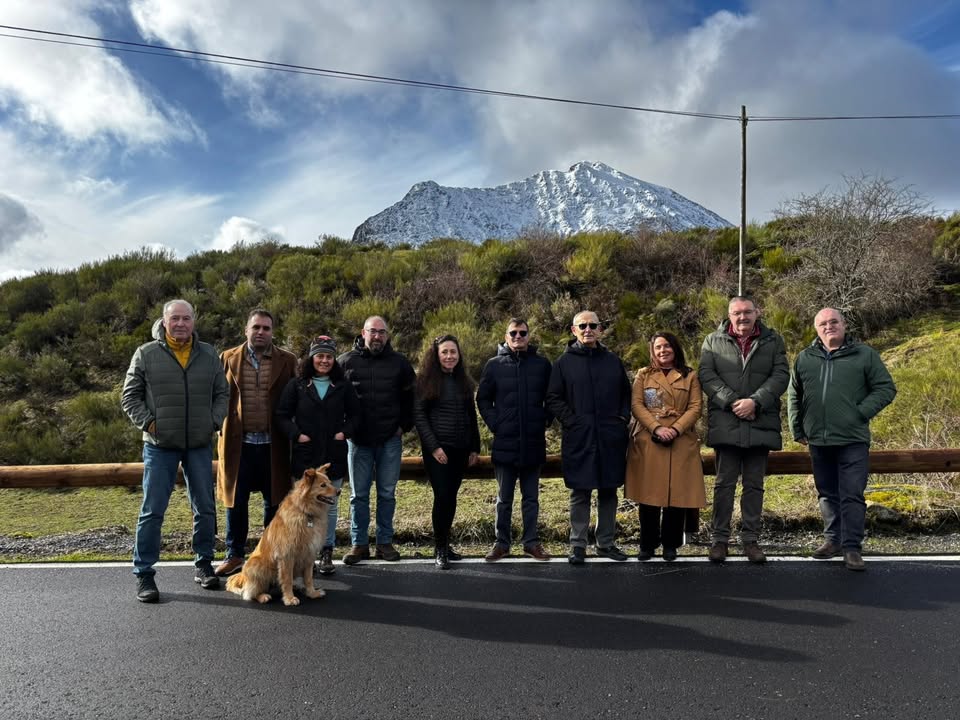 Grupo de personas junto a la carretera de acceso a Redipollos con montañas nevadas al fondo