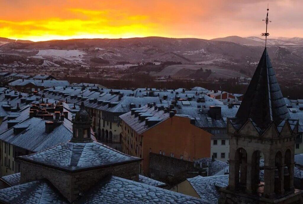 Amanecer invernal en Ponferrada con nieve cubriendo los tejados