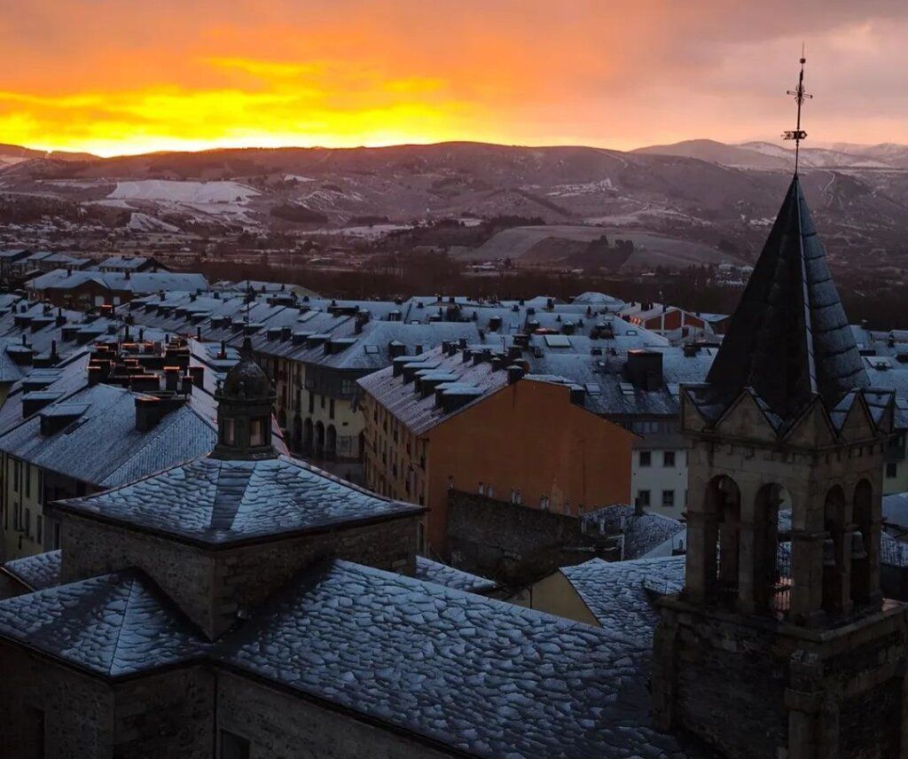 Amanecer invernal en Ponferrada con nieve cubriendo los tejados