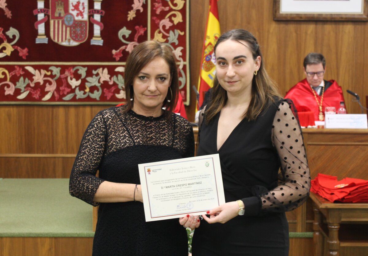 Dos graduadas de Derecho de la ULE sosteniendo un diploma en ceremonia