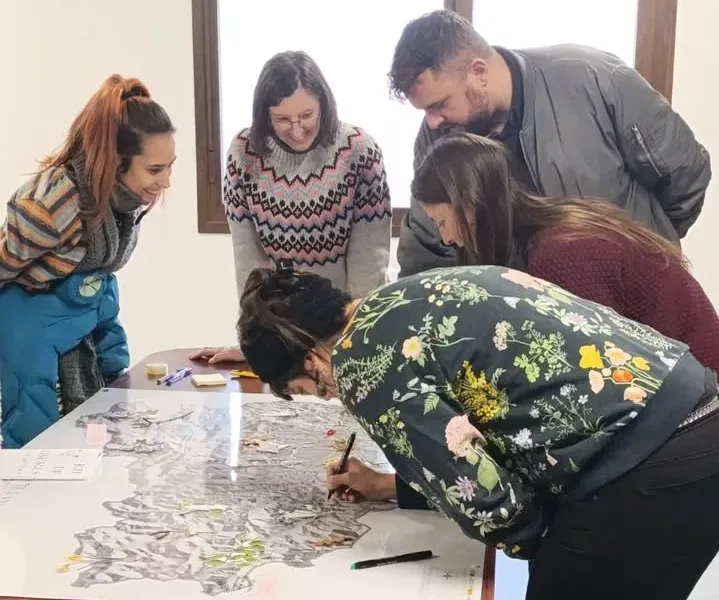 Grupo de personas trabajando en un mapa sobre desarrollo rural