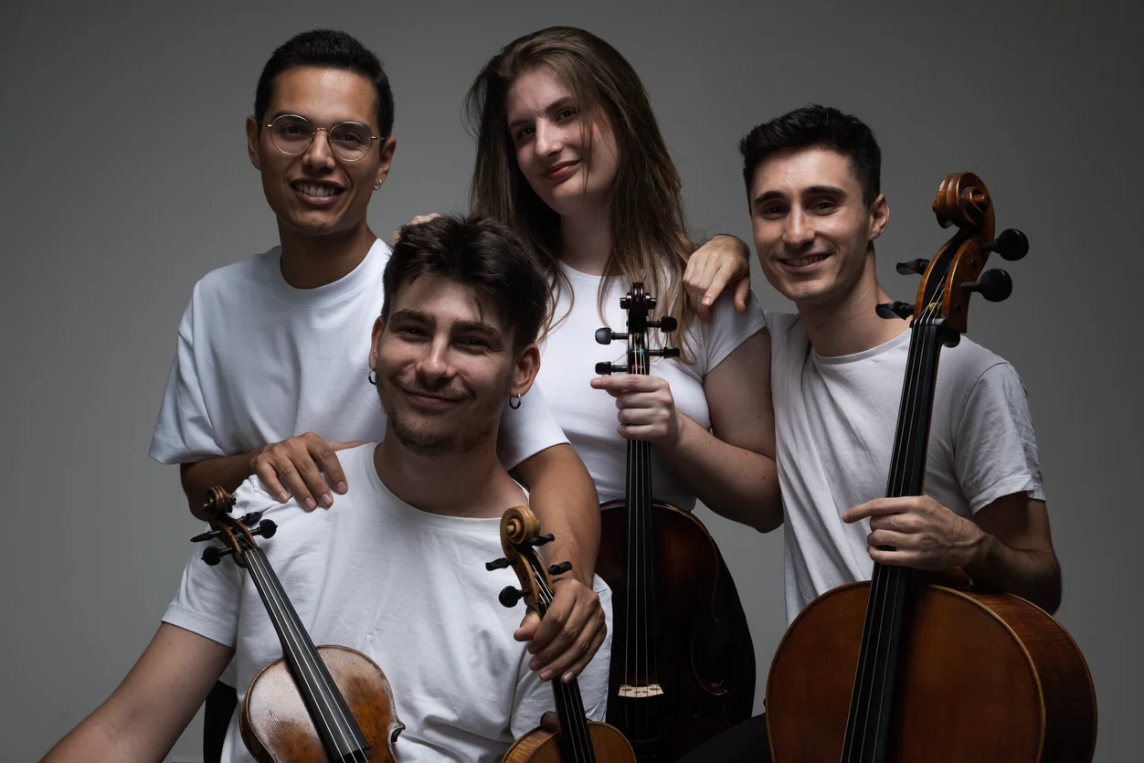 Cuarteto Vivancos posando con instrumentos musicales en un fondo neutro.