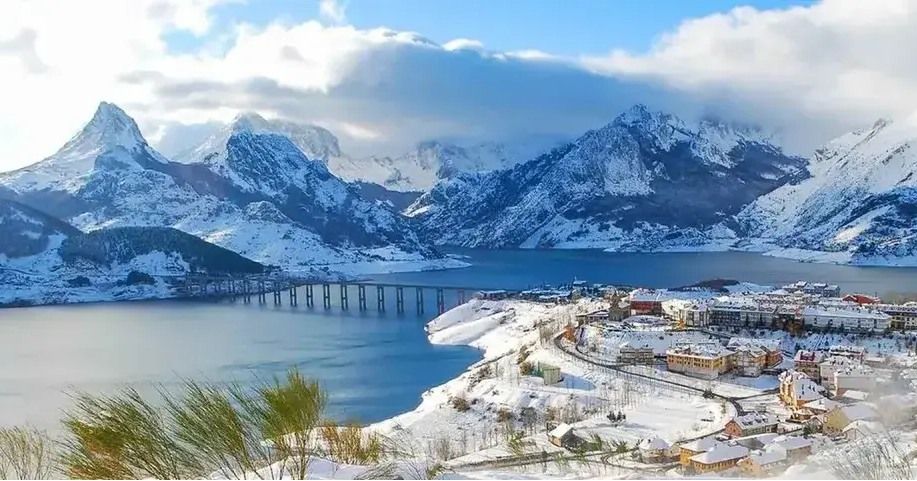 Vista panorámica de Riaño con montañas nevadas y embalse