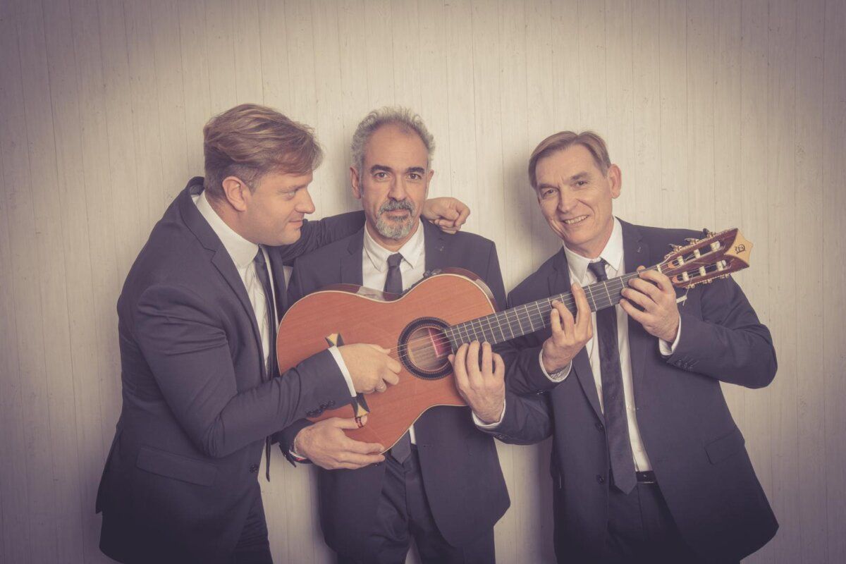 El Trío Bohemia posando con guitarras en un fondo neutro