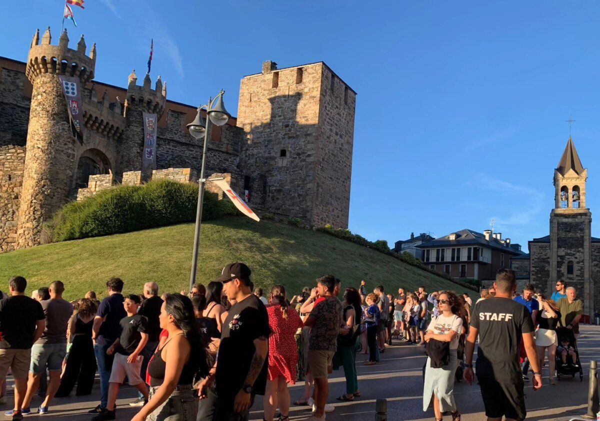 Multitud de personas en un evento en Ponferrada con un castillo al fondo