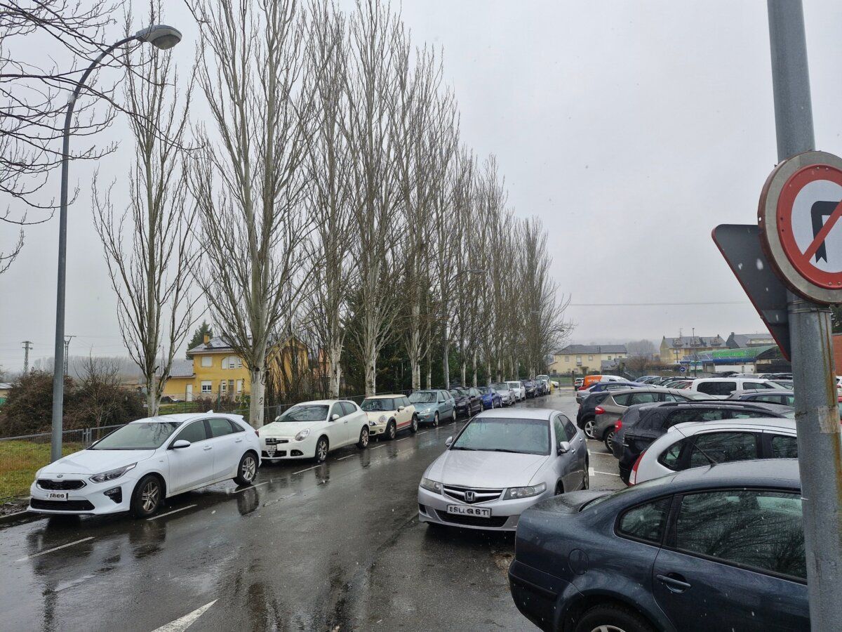 Zona trasera del hospital con chopos y coches estacionados