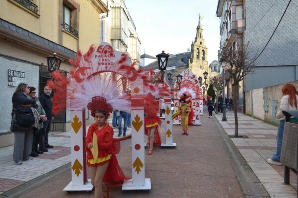 Desfile de carnaval en Bembibre con trajes coloridos y plumas