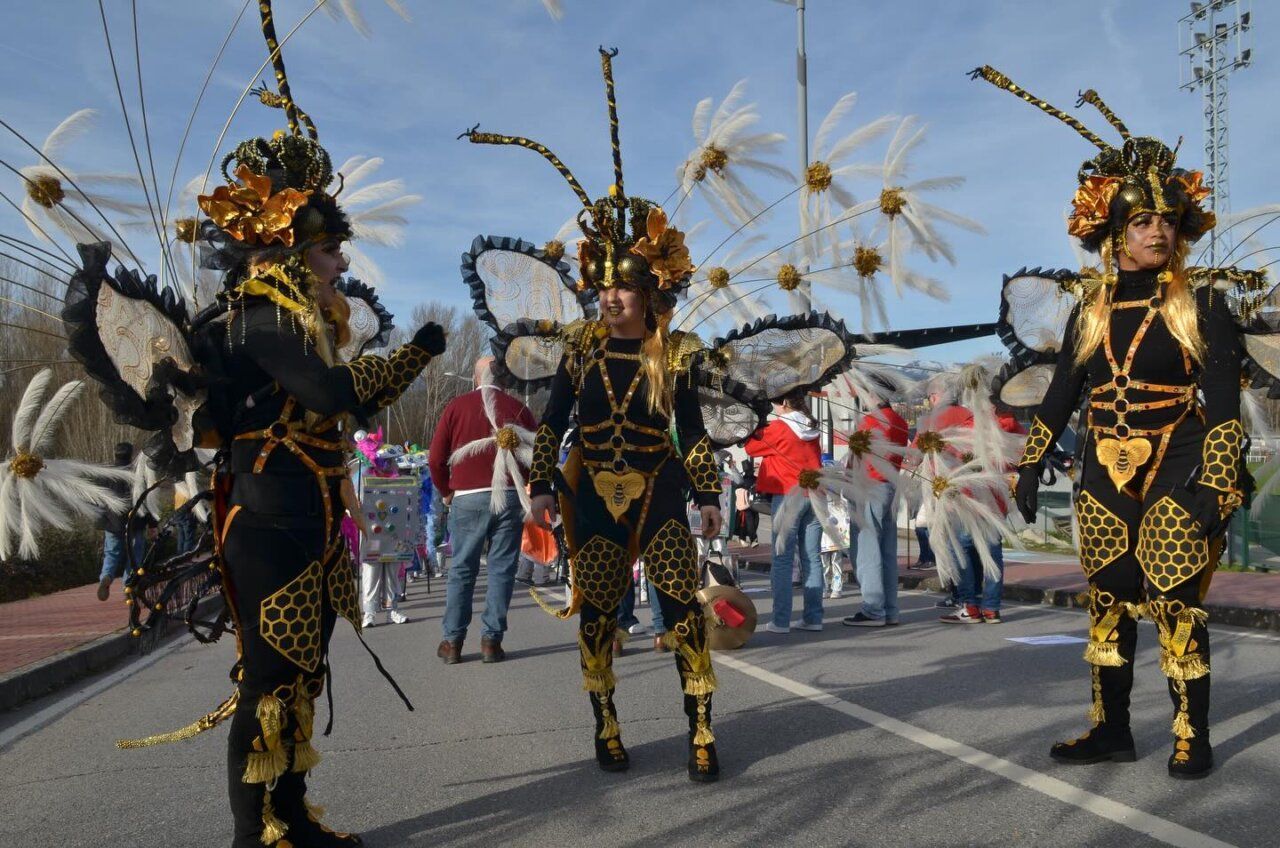 Tres personas disfrazadas en el Carnaval de Bembibre con trajes coloridos