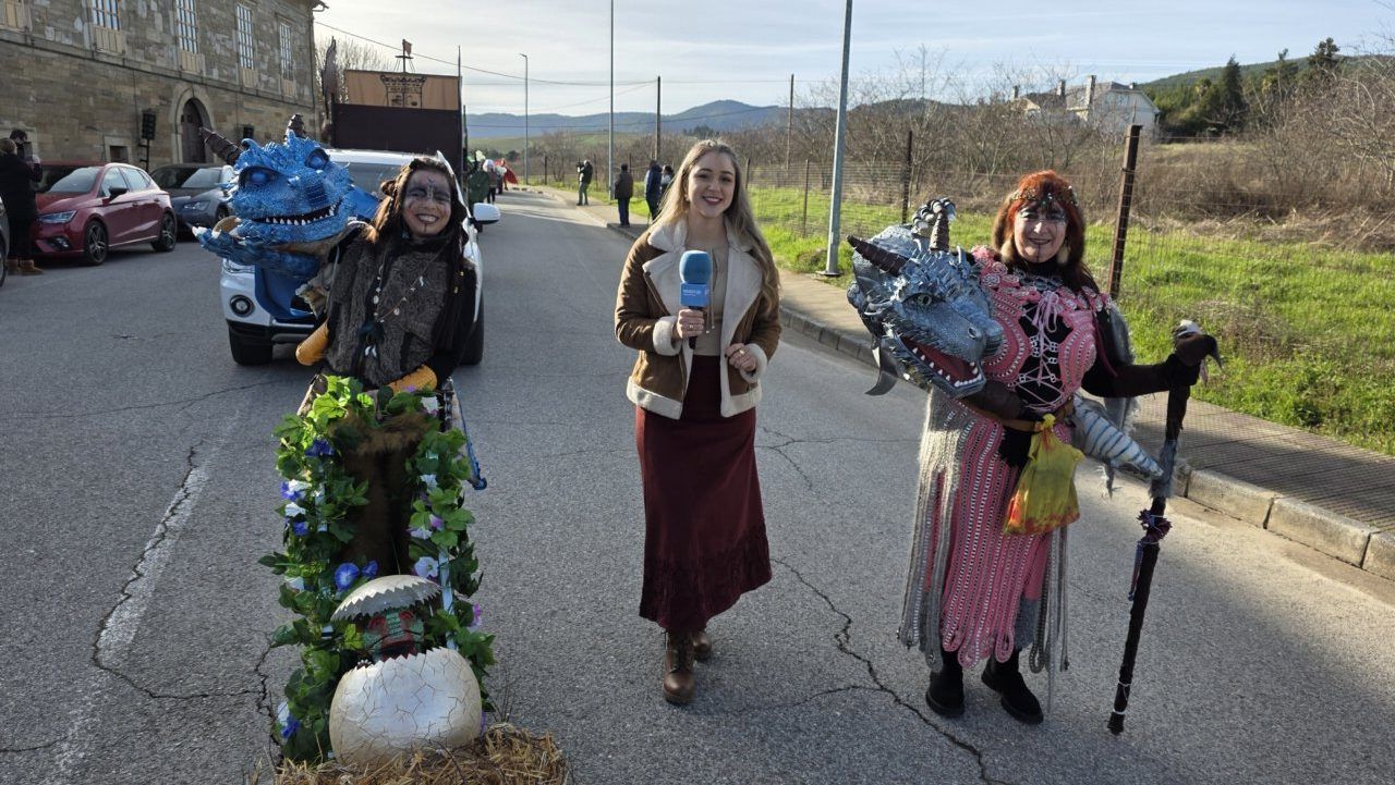 Participantes del Carnaval en Arganza con disfraces coloridos y un micrófono