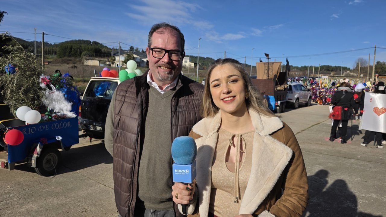 Dos personas sonrientes en el Carnaval de Arganza con decoraciones coloridas