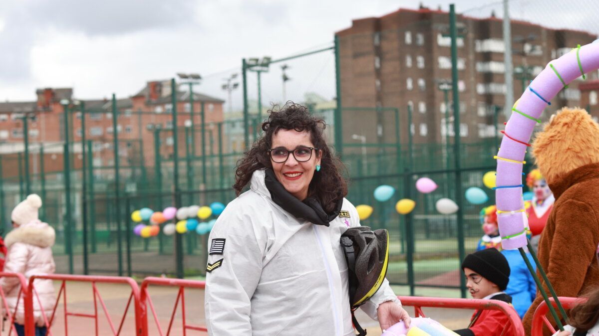 Mujer sonriente en el carnaval de Ponferrada con fondo de globos