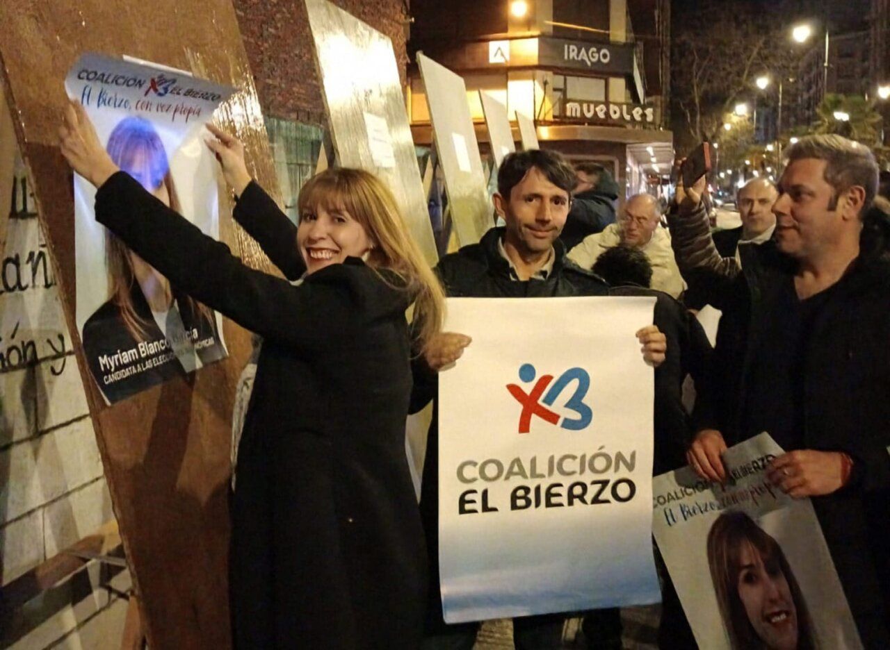 Miembros de la Coalición por El Bierzo pegando carteles en la campaña electoral.
