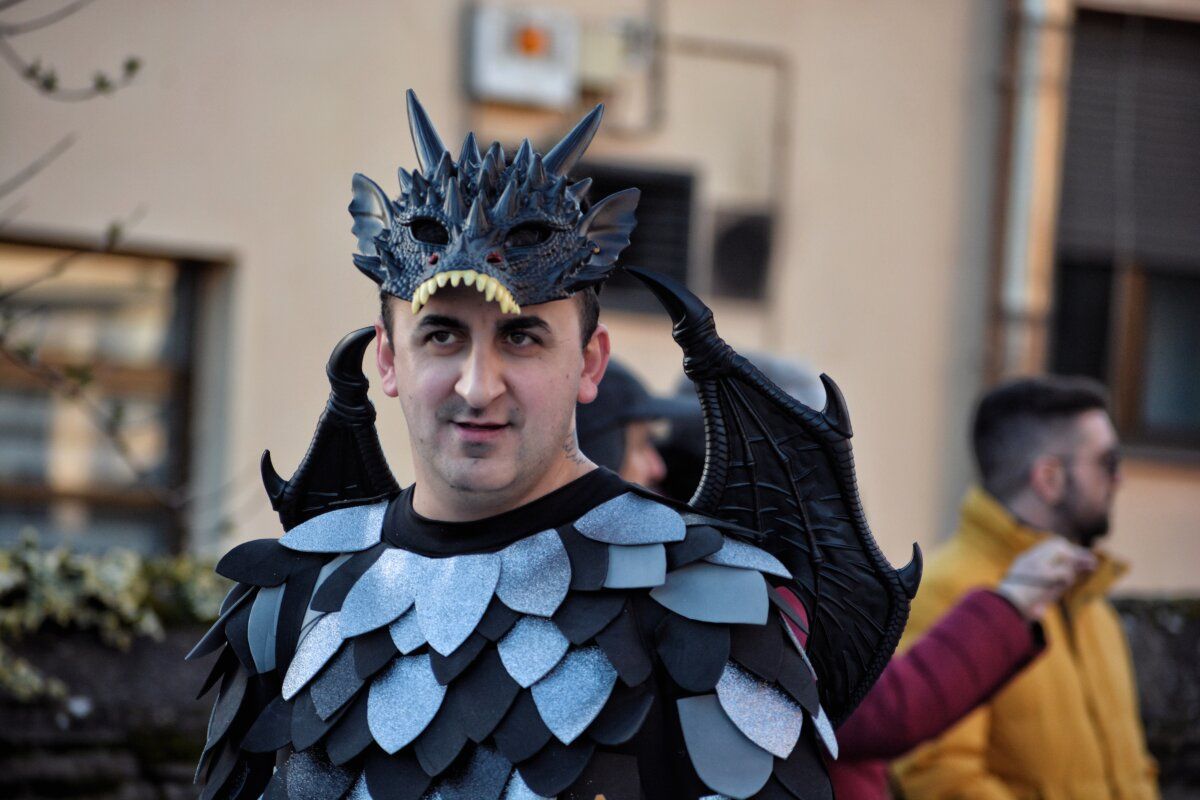 Hombre con disfraz de dragón en el desfile de carnaval