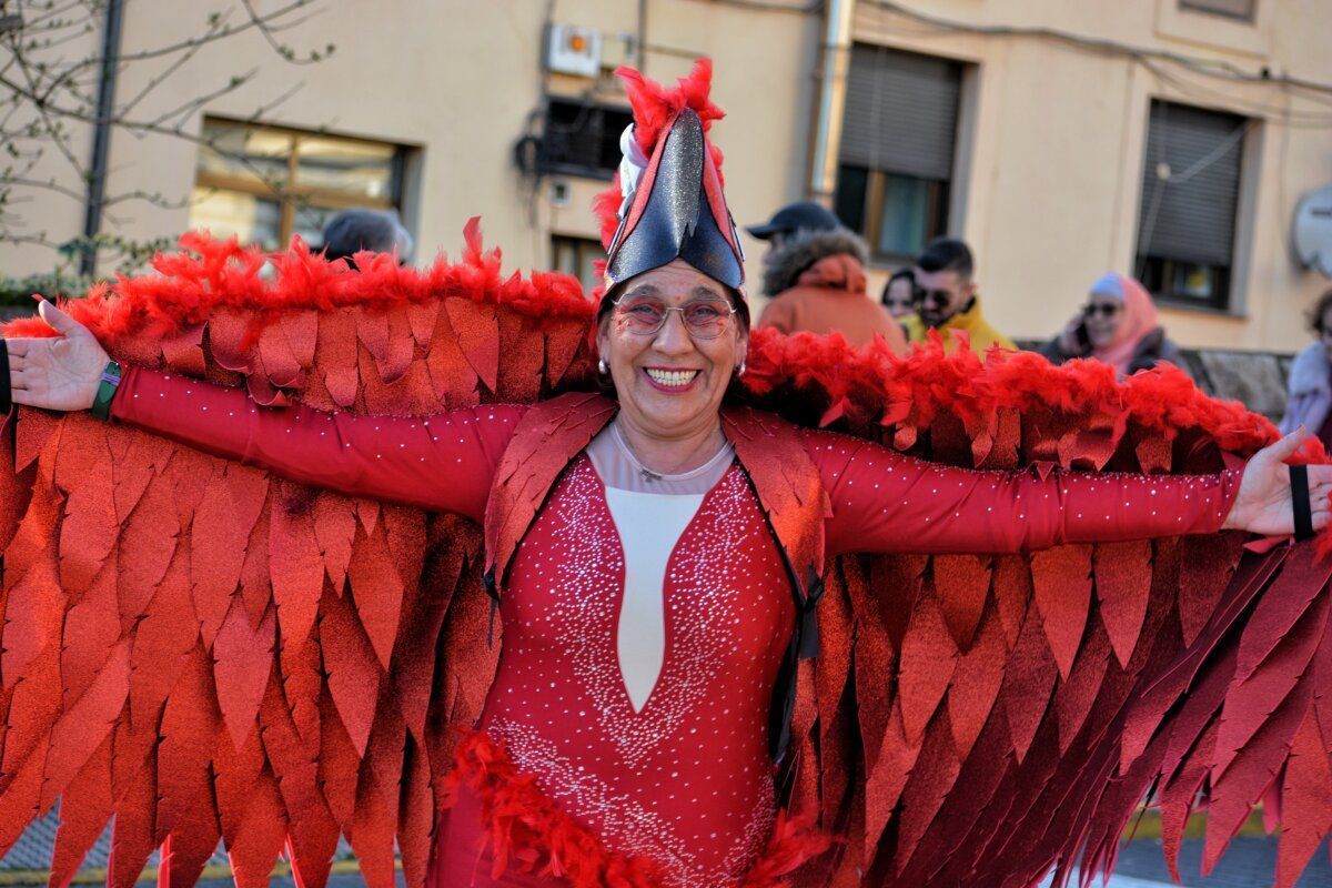 Mujer sonriente con disfraz rojo en desfile de carnaval