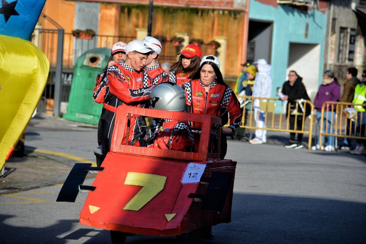 Participantes del desfile de carnaval en Toral de los Vados con un coche de cartón