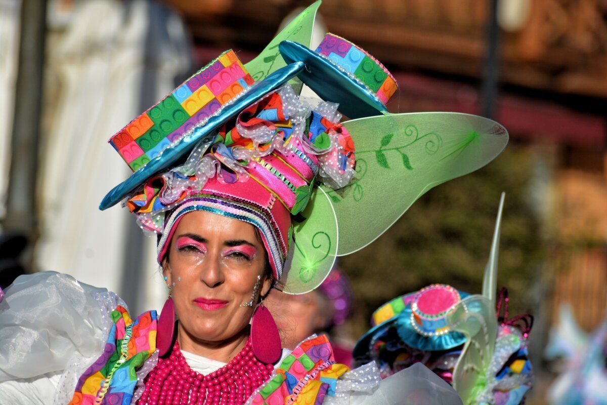 Mujer con un colorido disfraz y un gran sombrero en el carnaval