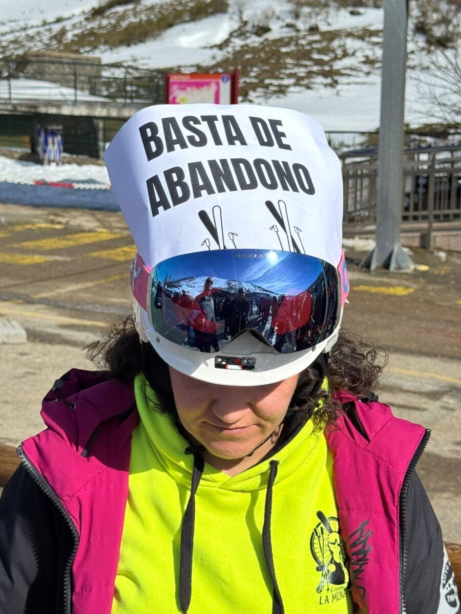 Persona con casco de esquí y pancarta en la estación invernal