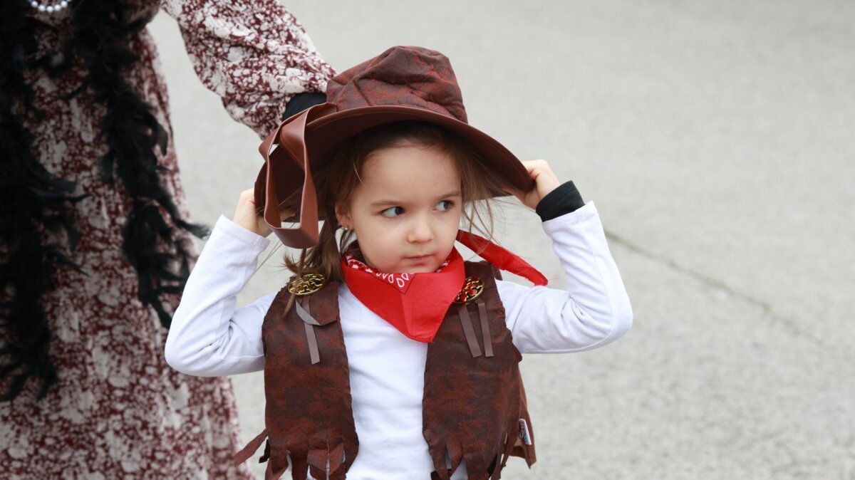 Niña con disfraz de vaquero y sombrero en un evento