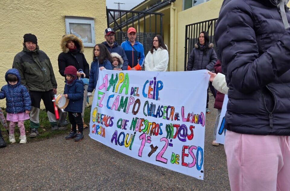 Concentración de AMPAs en un centro educativo con pancarta colorida.