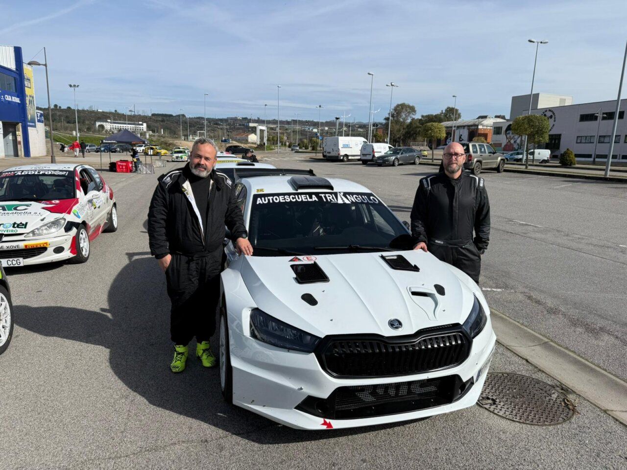 Pilotos junto a un coche de rally en Cacabelos