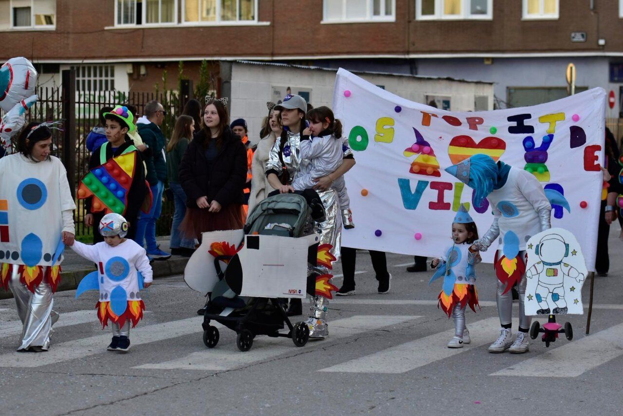Desfile del Carnaval de Bembibre con disfraces coloridos y pancarta