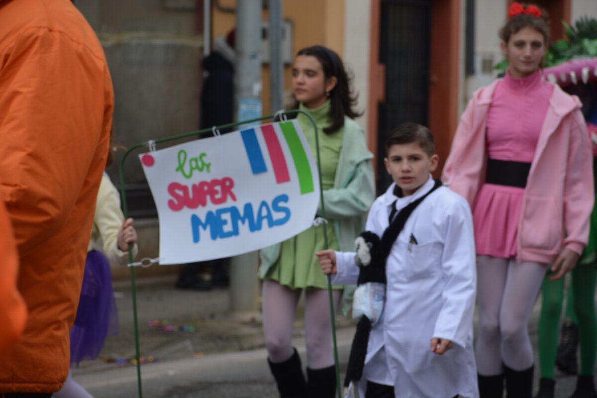 Niños en el carnaval de Camponaraya con un cartel colorido