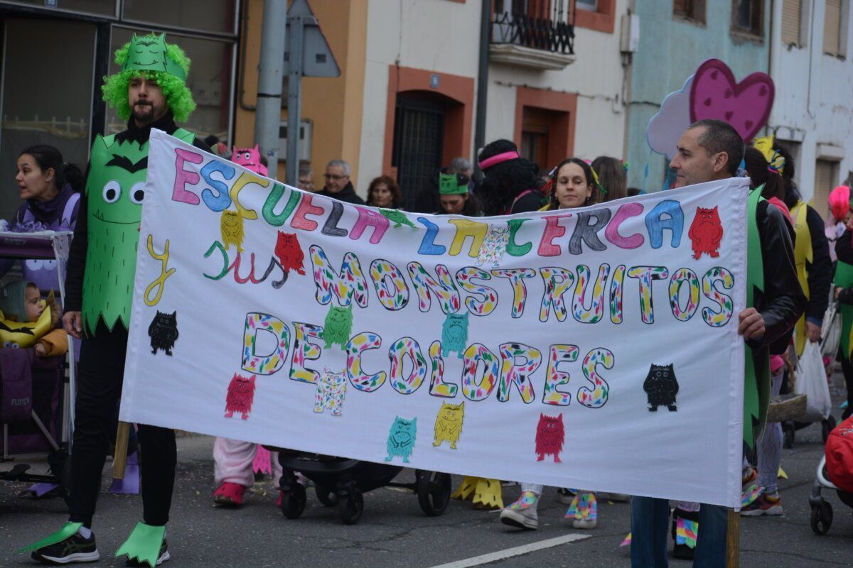Participantes del carnaval en Camponaraya con un cartel colorido