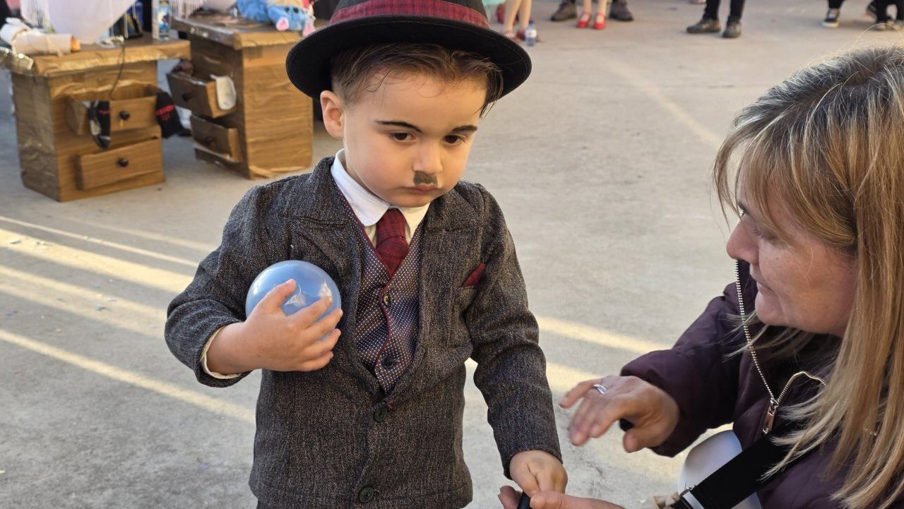 Niño disfrazado en el carnaval de Arganza sosteniendo un globo