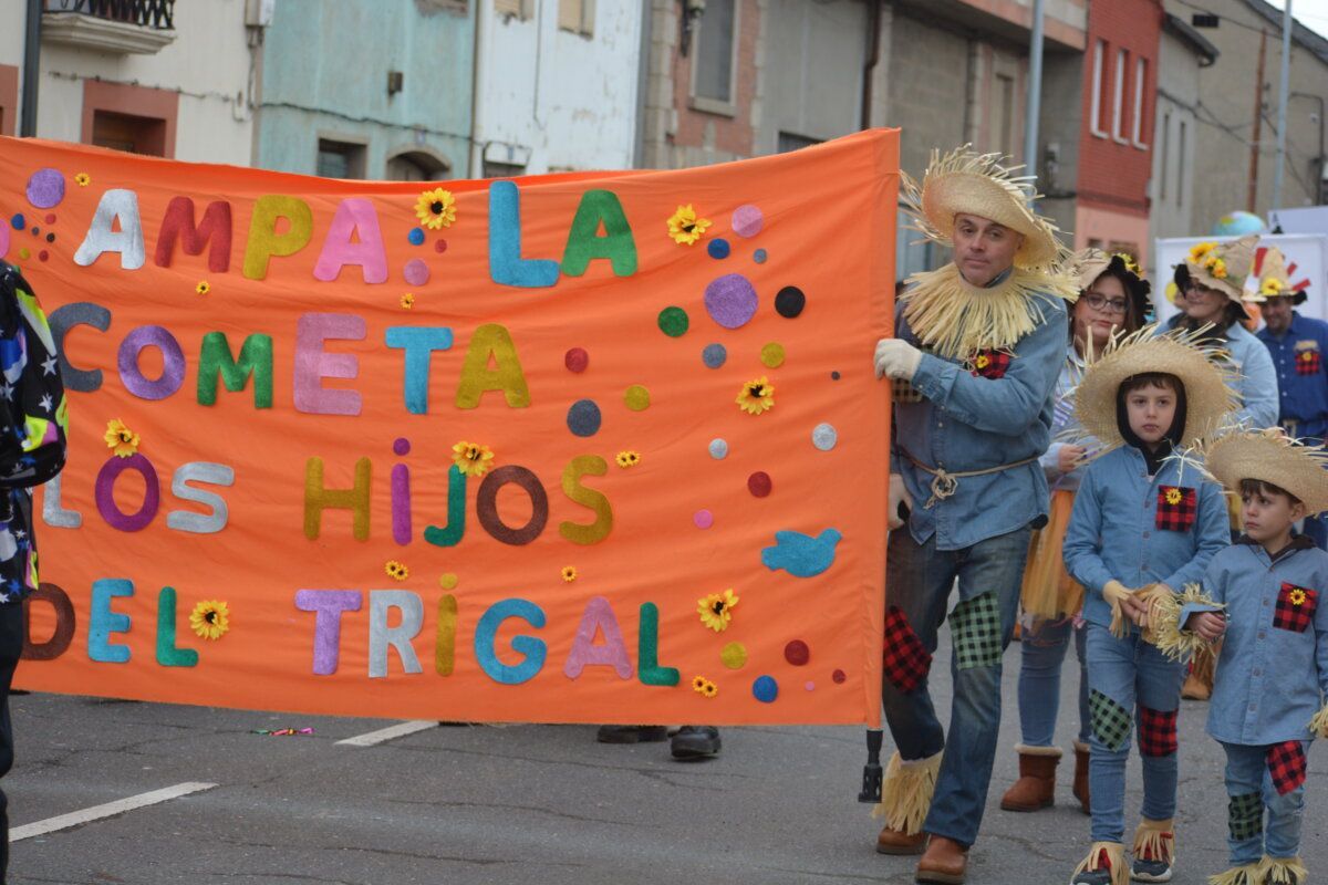 Participantes del carnaval de Camponaraya con un gran cartel colorido