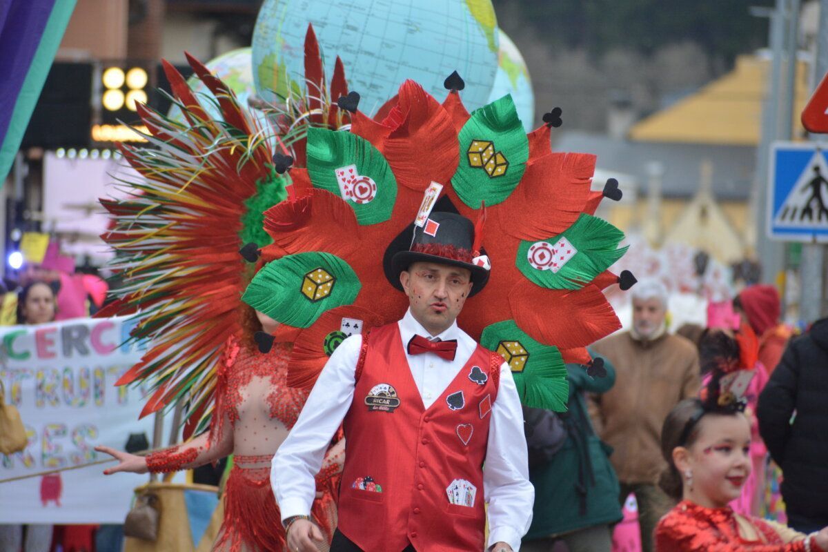 Participante del carnaval de Camponaraya con disfraz colorido y plumas.