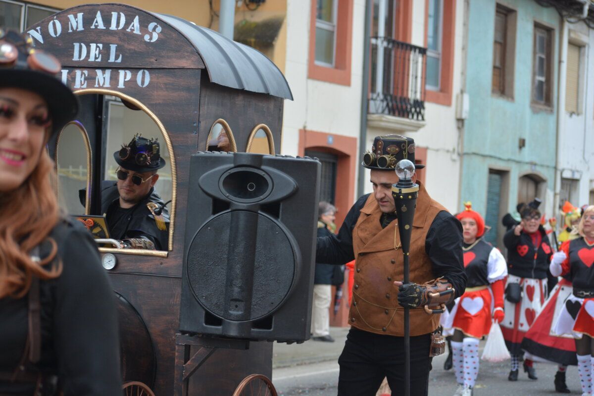 Participantes del carnaval de Camponaraya con vestimenta colorida y un carro