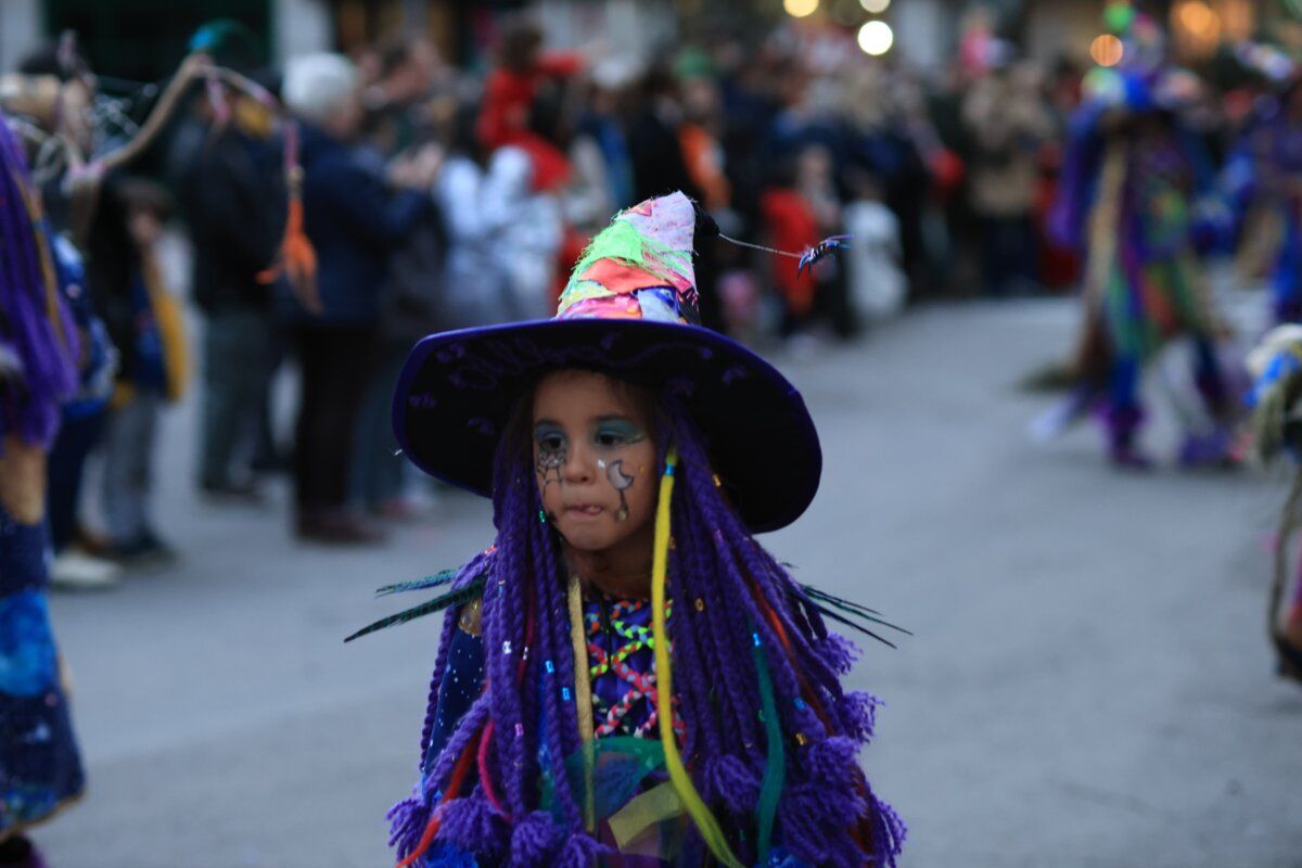 Niña disfrazada con un sombrero colorido en el carnaval de Ponferrada