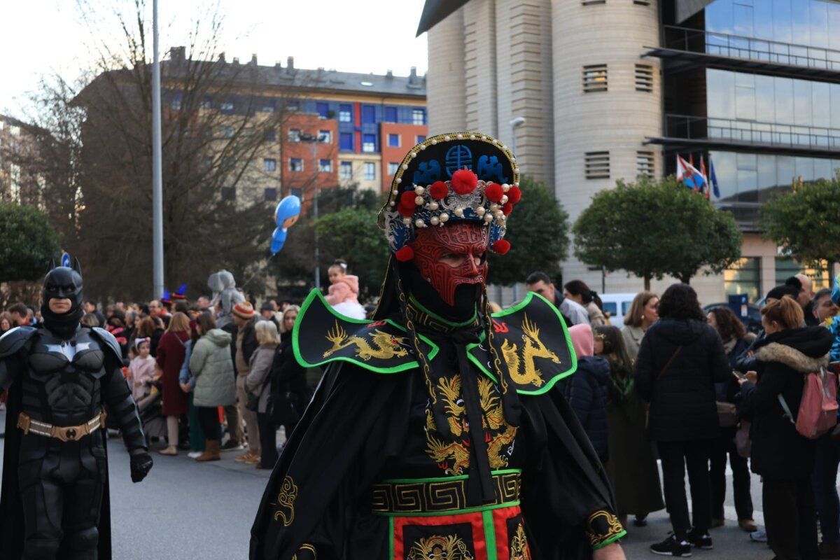 Participante del carnaval en Ponferrada con disfraz colorido y máscara